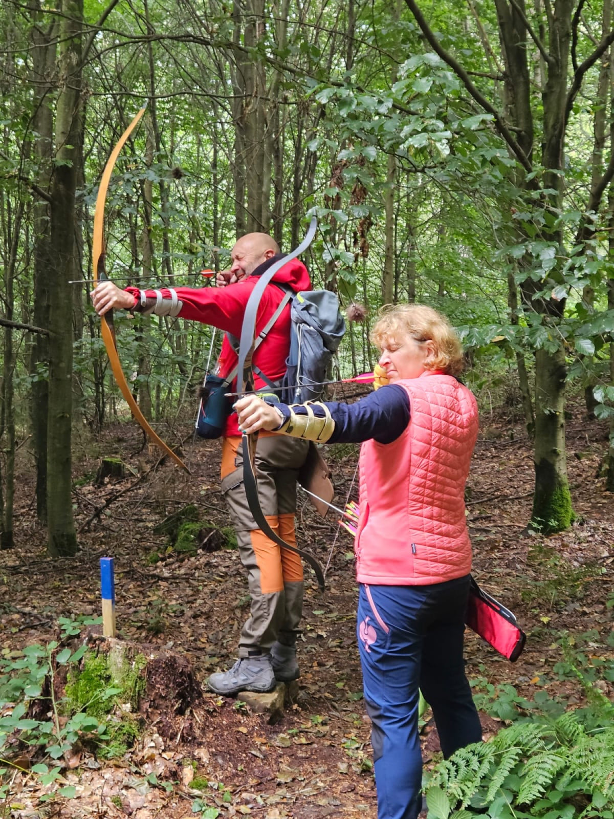 Zwei Bogenschützen mit Langbögen nebeneinander im Wald